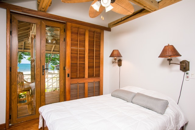 Izba s drevenými posuvnými dverami a veľkou bielou posteľou