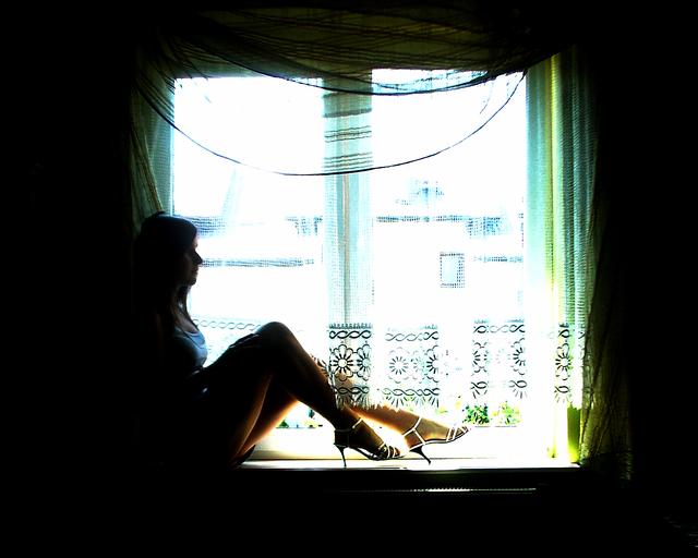 Žena sedí pri okne